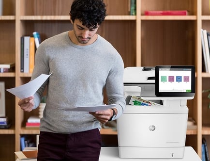 man standing next to a hp color laserjet enterprise flow mfp m578c