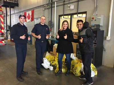 smartprint team members at the firehall with grocery bags for the winter food drive